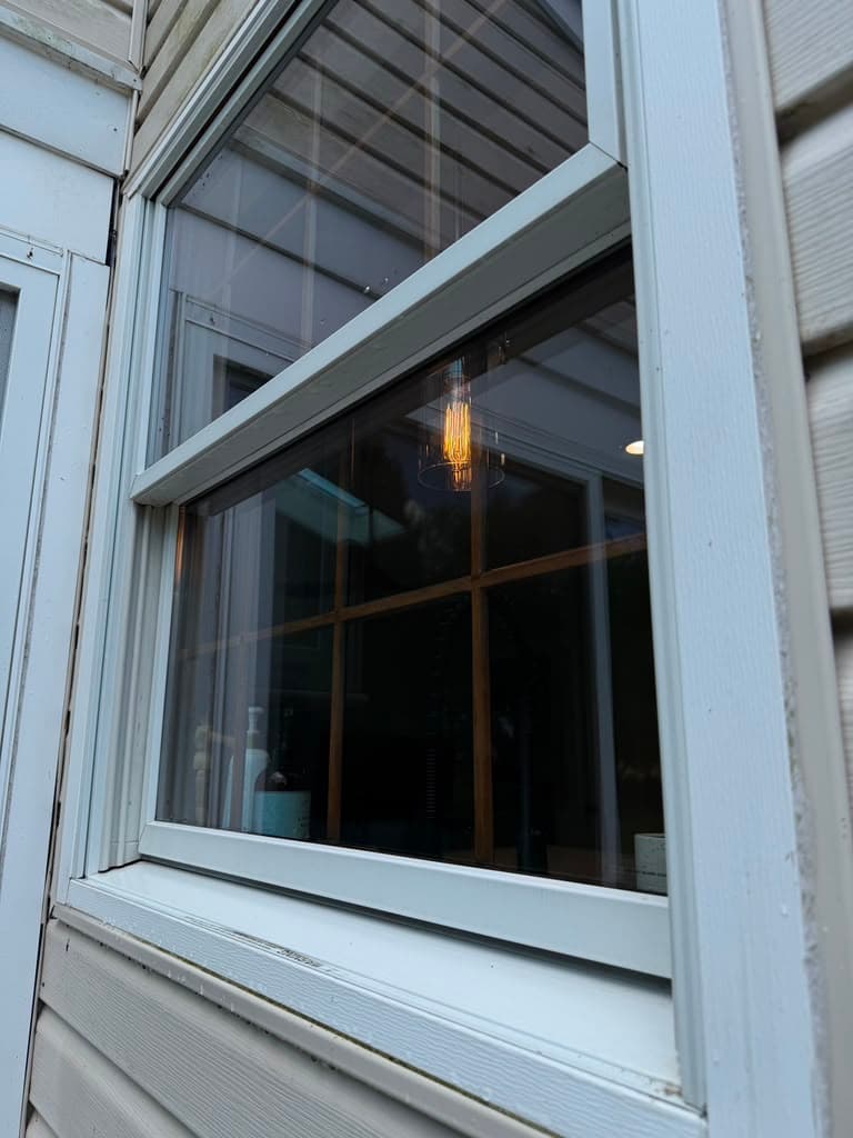 The same window frame and sill cleaned back to white, with the sash opened