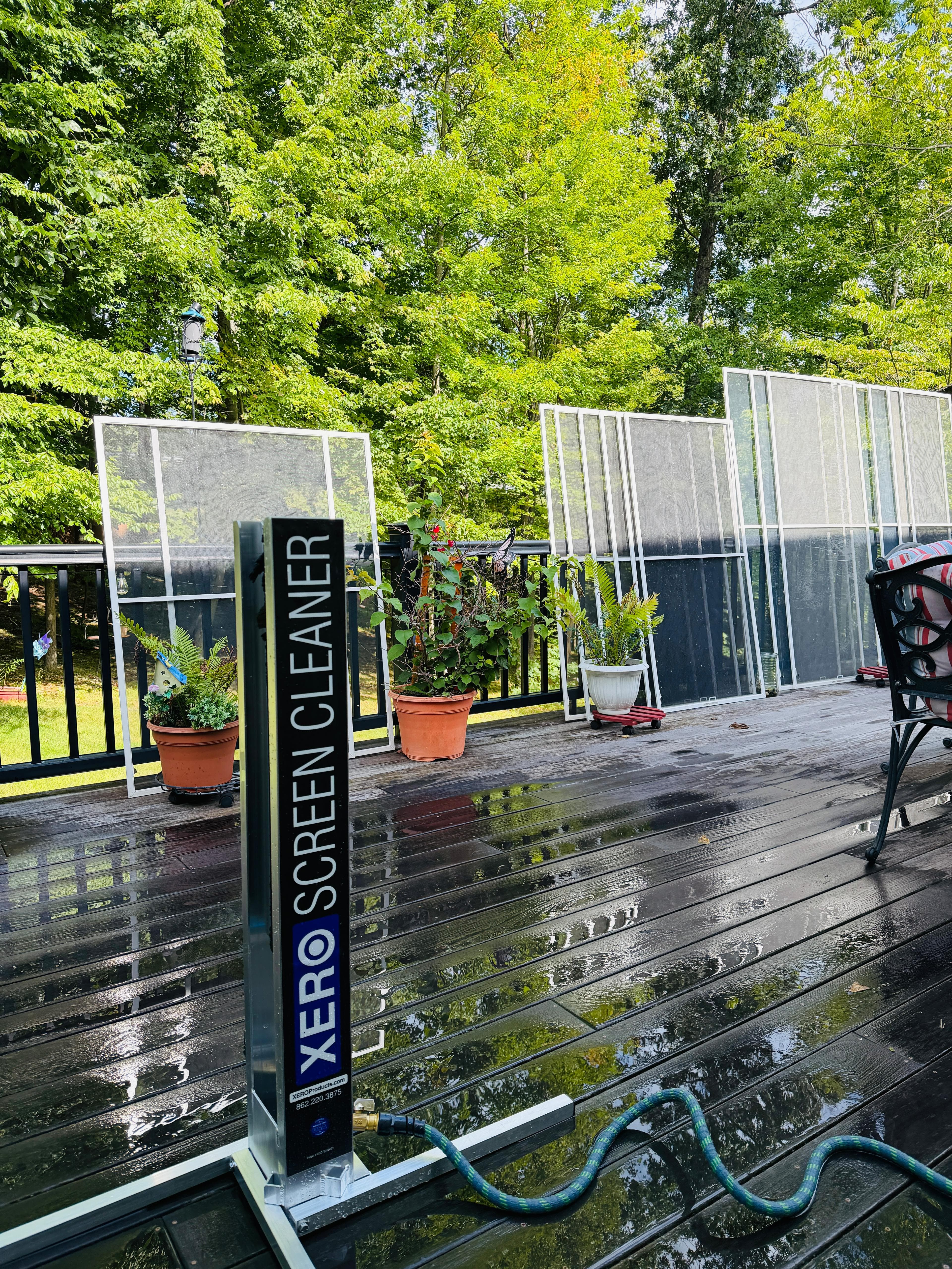 XERO screen cleaning machine on a deck with window screens lined up behind it
