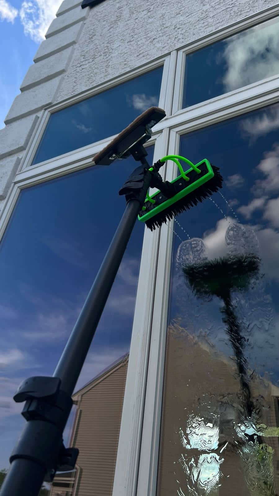 Water fed pole with a soft brush head washing exterior window glass with purified water in Bucks County